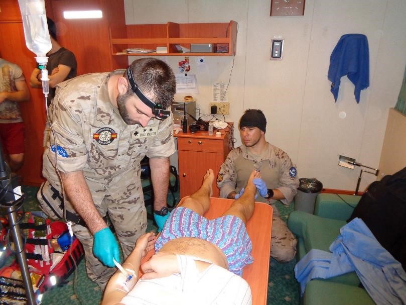 The frigate 'Victoria' provides medical assistance to a crew member of a merchant ship