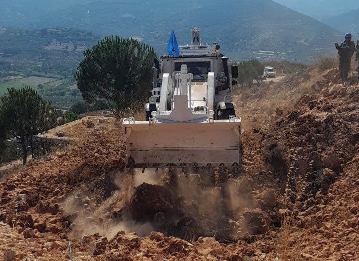Maquinaria pesada rellenando el cráter de una explosión