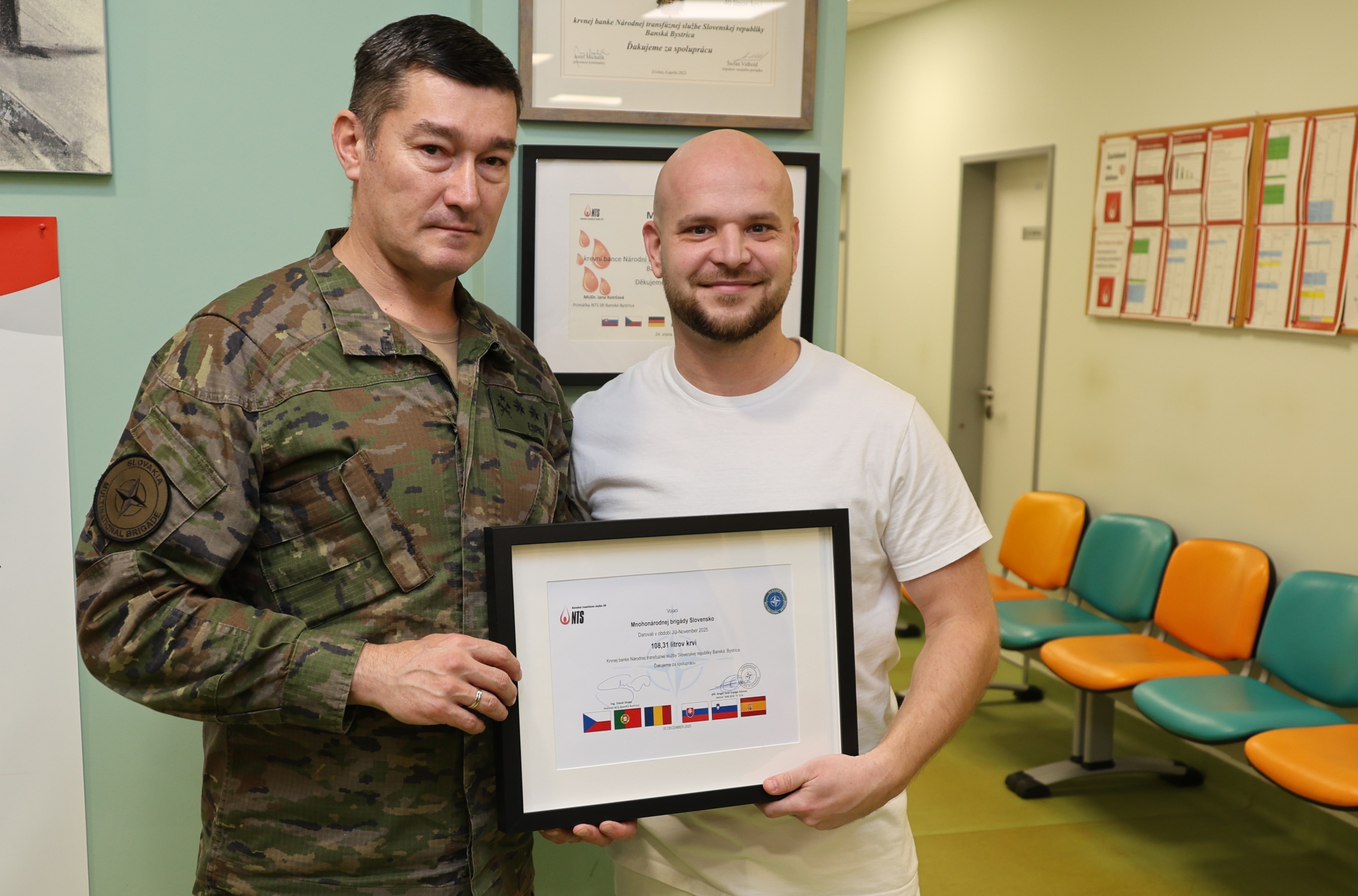 Coronel Espiga y director centro de transfusión posando con cuadro conmemorativo