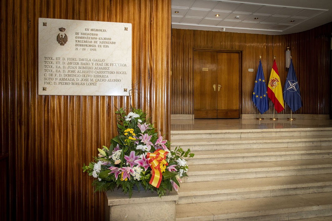 Centro de flores ante la placa homenaje