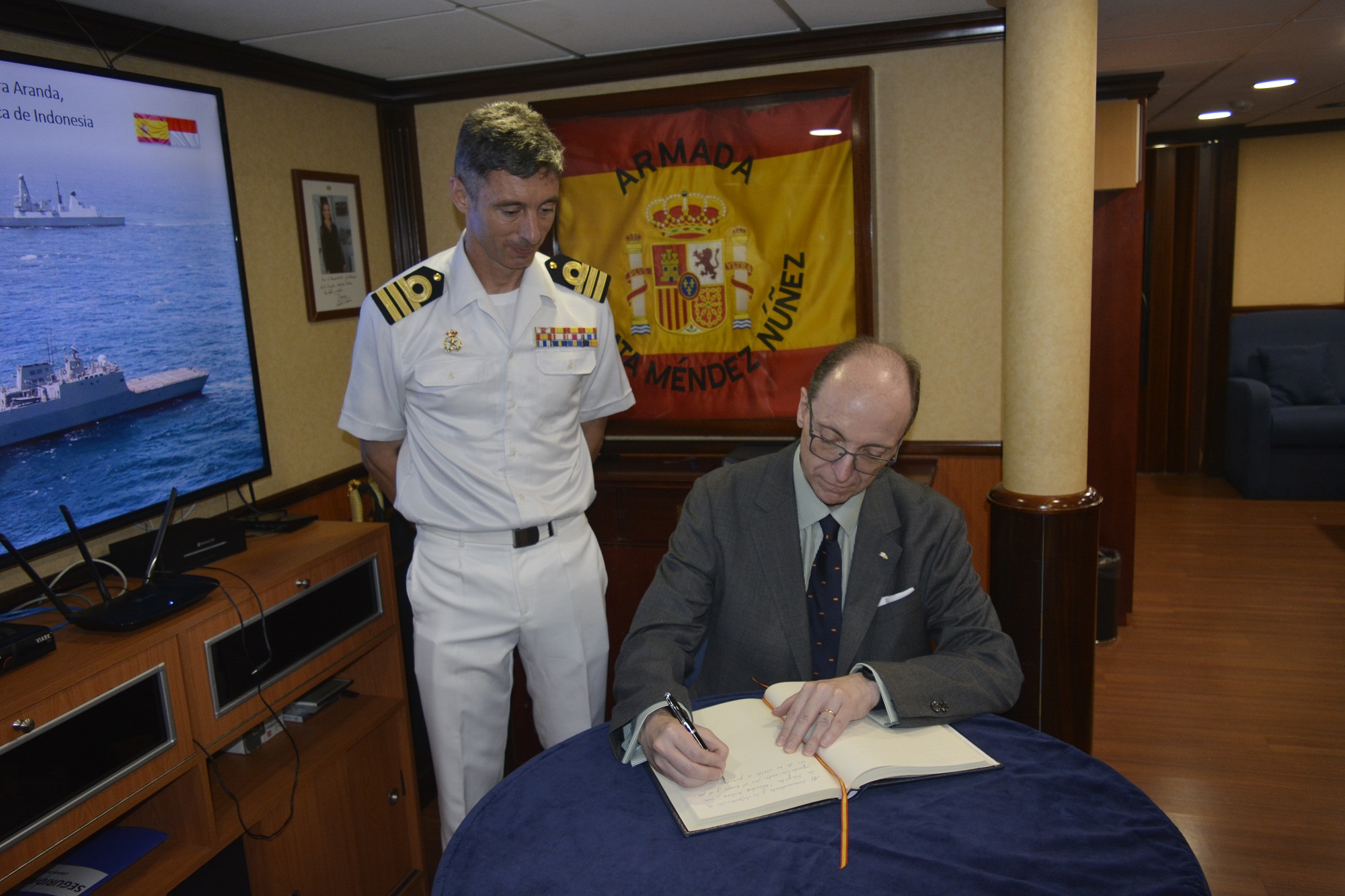 El embajador firma en el libro de visitas del buque