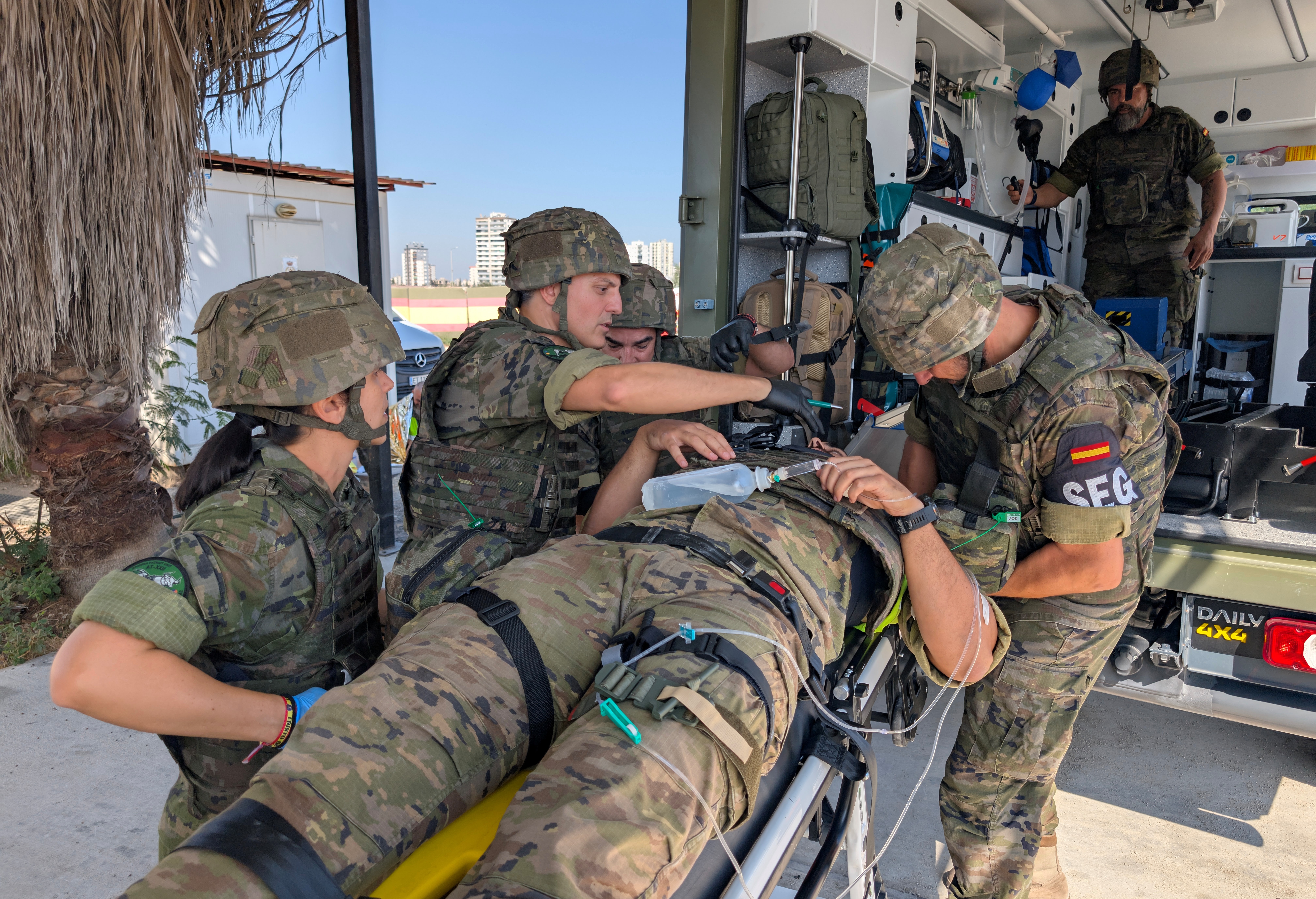 An injured soldier is carried to the ambulance by the medical team