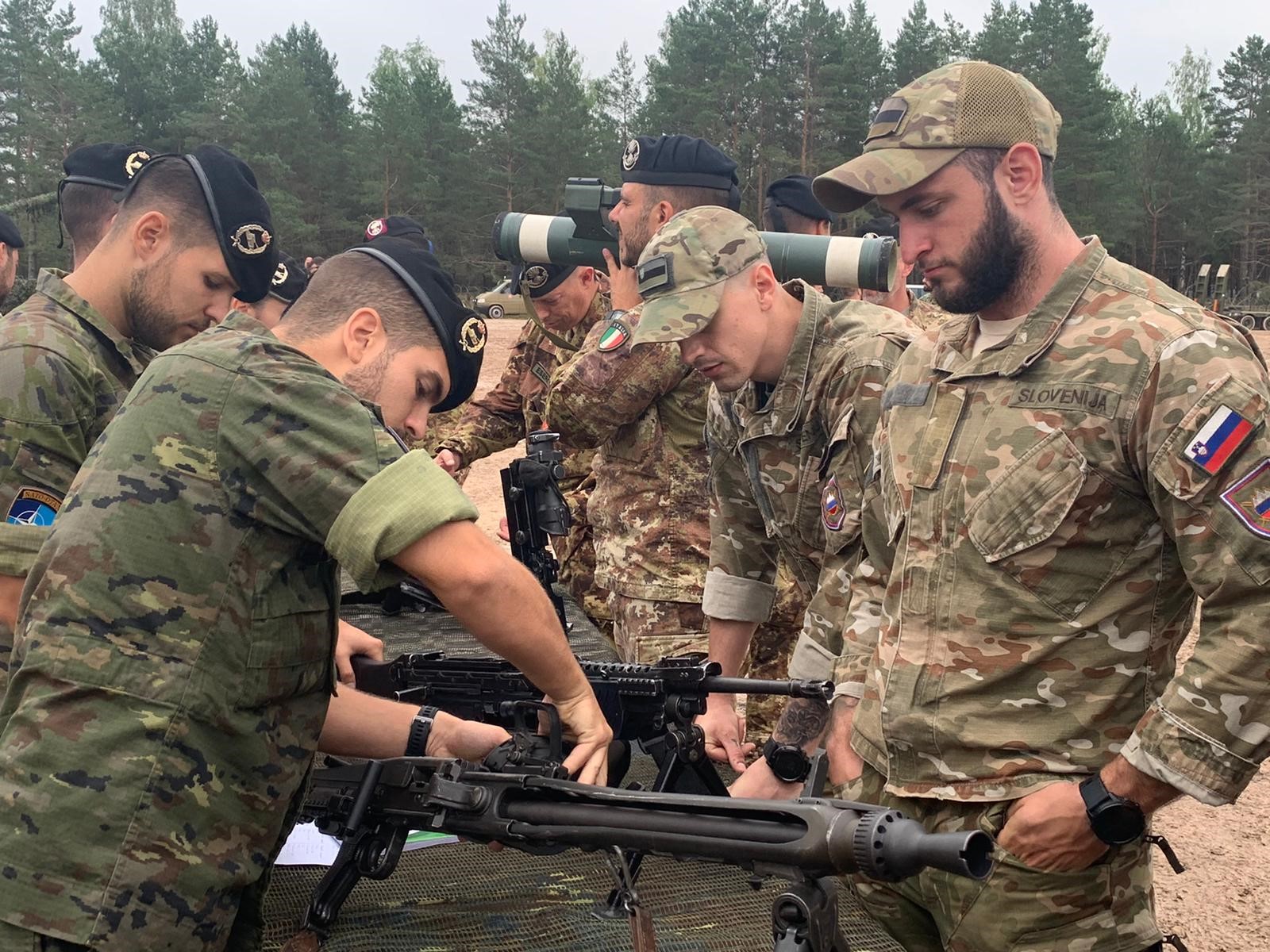 Spaniards showing their weaponry to Slovenian troops