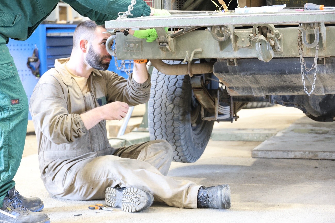 Mechanic repairing the exhaust pipe of an Aníbal vehicle