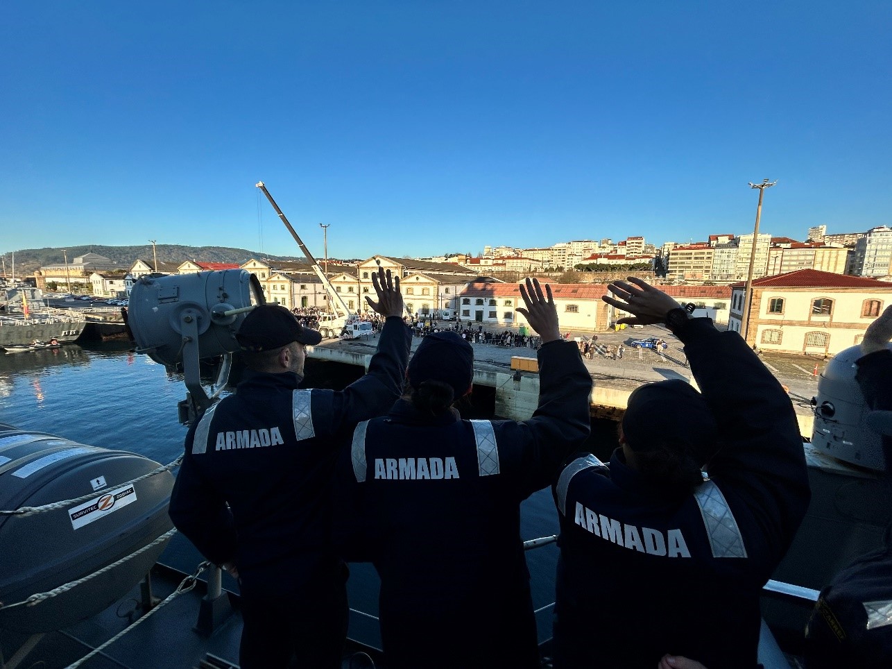 The ship's crew greets their relatives on the quayside.