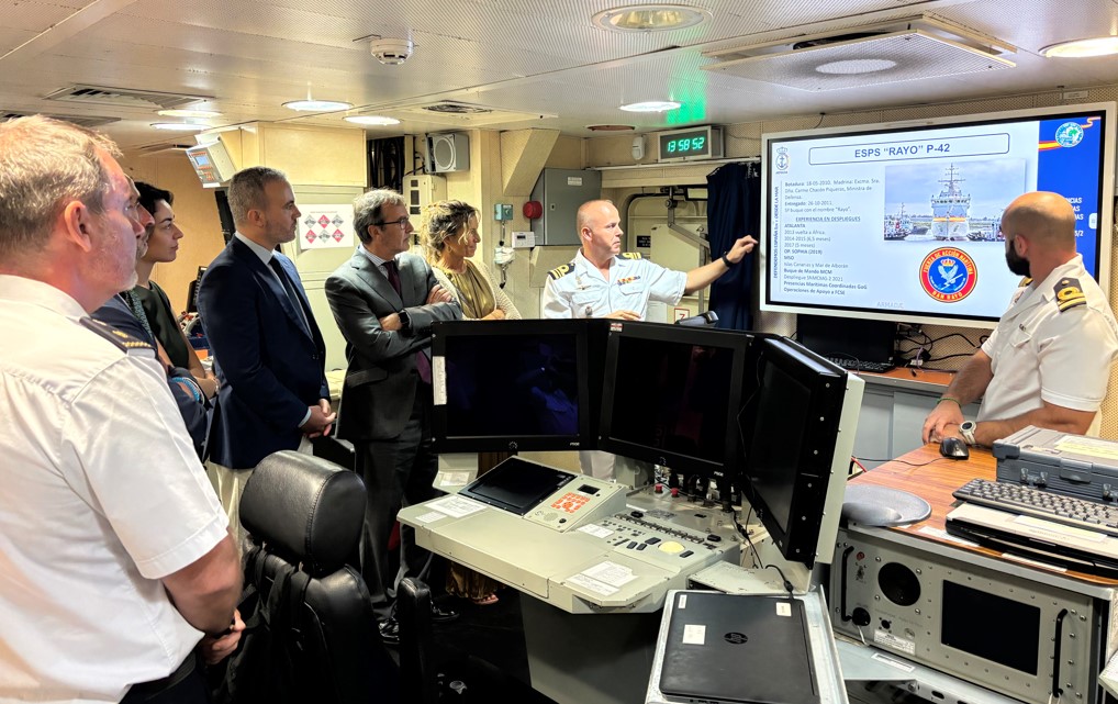 The commander explains the ship's operational capabilities to the Ambassador and his accompanying delegation