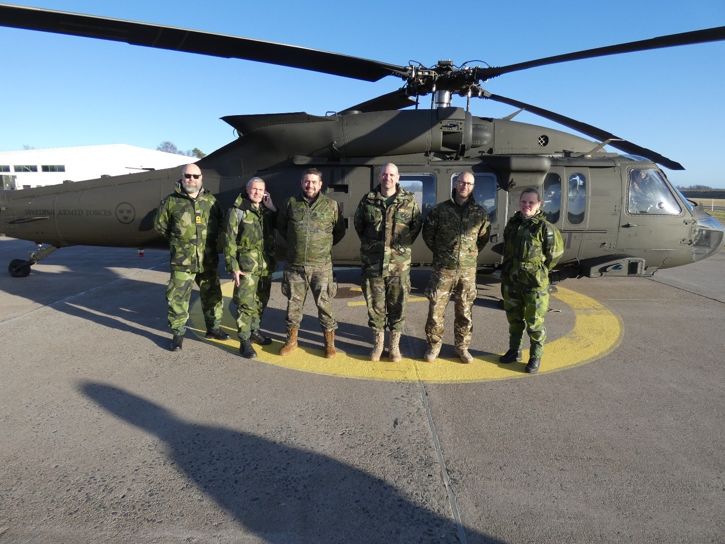 Inspection team in front of a Sikorsky UH-60M