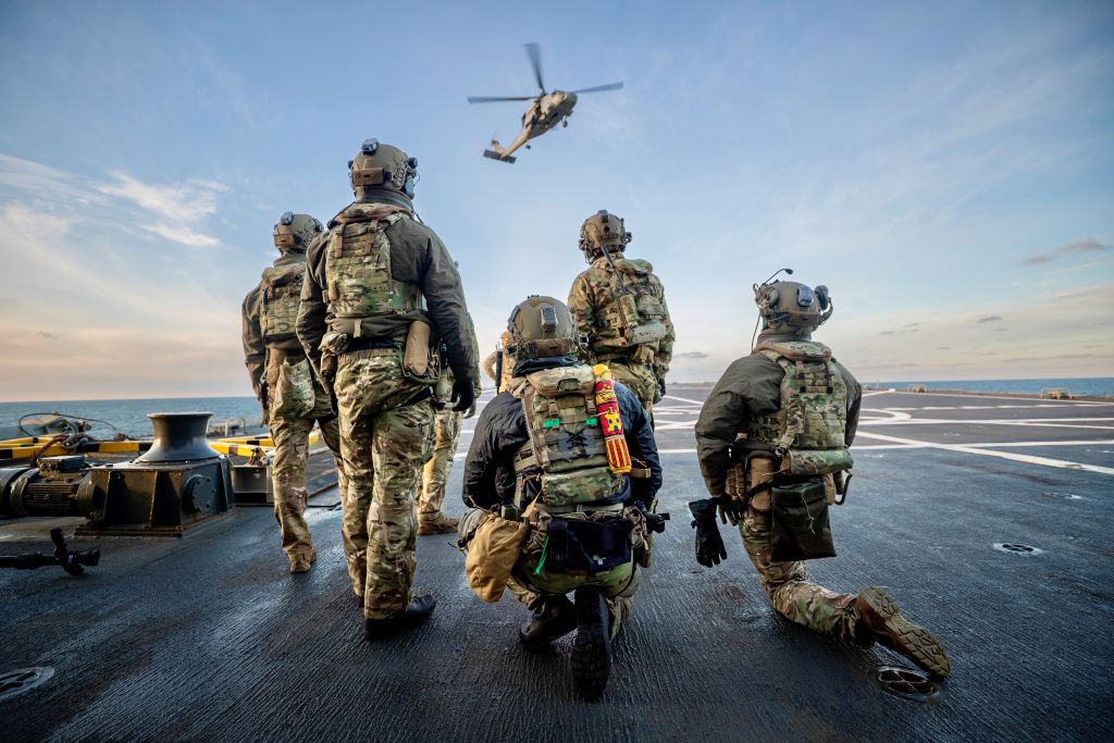 Personnel awaiting evacuation on a ship’s deck